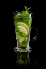 Fresh homemade lemonade with mint and lime in iced glass isolated on black background