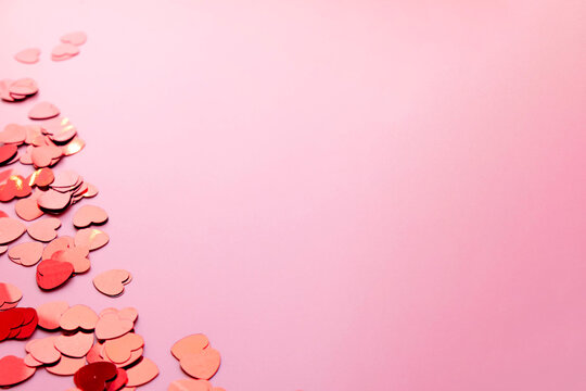 pink background with place for text decorated with heart shaped confetti. happy valentines day, copy space