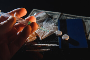 Purchase, possession and sale of drugs is punishable by law. Many types of narcotics and drugs represented on table.