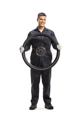 Mechanic holding a bicycle wheel and smiling at camera