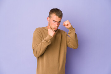 Young caucasian handsome man showing fist to camera, aggressive facial expression.