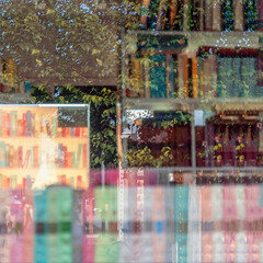 Abstract Blurred background with reflections of bookshelfs with colorful books and city views