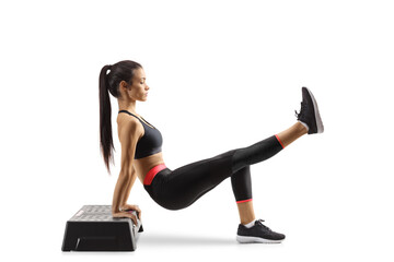 Young female exercising with a step aerobic platform on the ground
