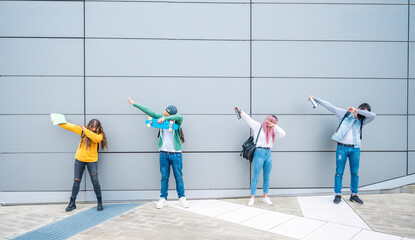 Happy multiracial teenage friends in casual clothes dancing dub dance on grey wall background after school.- New normal lifestyle concept with young students having fun together near to the campus - obrazy, fototapety, plakaty