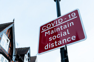 Solihull, United Kingdom - December 1 2020: Covid-19 'Maintain Social Distance' signpost after UK government announce tier system