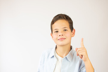 A handsome young boy in the blue shirt holds his thumb up