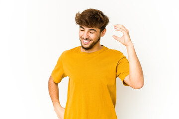 Young arab man on white background joyful laughing a lot. Happiness concept.