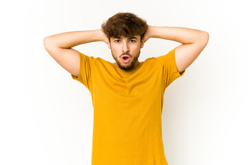 Young arab man on white background screaming, very excited, passionate, satisfied with something.