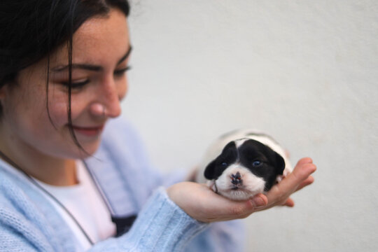 Young woman holding her newborn dog.