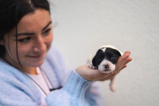 Young woman holding her newborn dog.