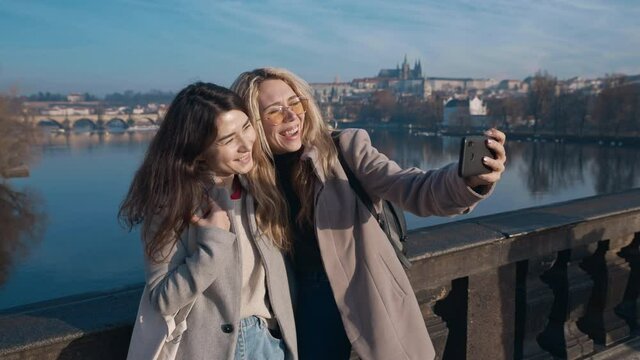 Female friends taking selfe in Prague. Travel, friendship, youth, millenial, blogger, fame social media concept. Filmed on REd 4k, 10 bit color