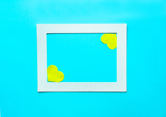 Paper yellow hearts in frame on light blue background. Valentine's Day, Mother's or Woman's Day greeting cards. Beautiful spring concept.
