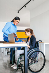 Hispanic woman in wheelchair with her colleagues at workplace in Mexico City