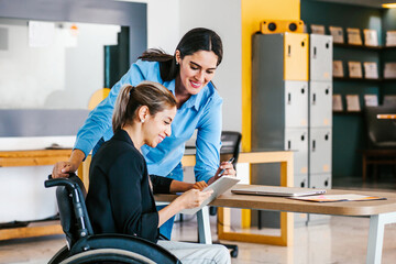 Latin woman in wheelchair with her colleagues at workplace in Mexico City