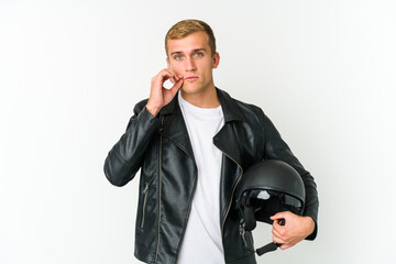 Fototapeta premium Young caucasian man holding a motorbike helmet isolated on white background