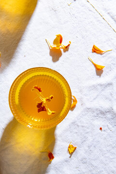 Overhead view of turmeric ginger herbal tea garnish with petals served on table