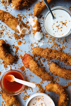 Overhead View Of Chicken Fingers With Sauce And Dip On Table