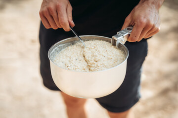 Close up of man holding saucepan with porridge