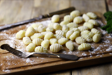 Selective focus. Macro. Raw gnocchi on a wooden board. Cooking gnocchi.