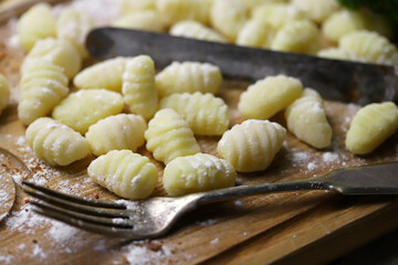 Selective focus. Macro. Raw gnocchi on a wooden board. Cooking gnocchi.