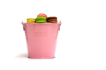 Fototapeta na wymiar Macarons multicolored in a pink bucket on a white background