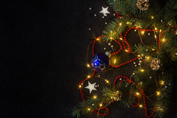 Christmas background for postcards. LED garland on a dark background. Christmas tree branches.