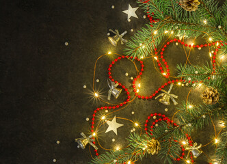 Christmas background for postcards. LED garland on a dark background. Christmas tree branches.