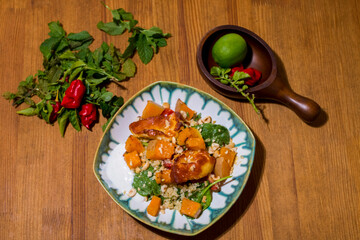 Healthy plate with fried vegetarian tofu and greek halloumi with grilled vegetables and yogurt sauce. Mediterranean food dishes with oriental couscous. Lemons and hot peppers around in decorative way
