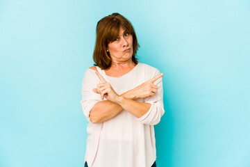 Fototapeta premium Senior caucasian woman isolated points sideways, is trying to choose between two options.