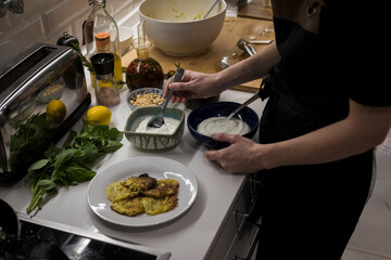 Young charming Swedish woman cooking at home in her kitchen, preparing healthy mediterranean food...