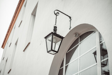 a small electric lamp with a lamp hanging over the entrance to the house