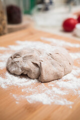 Homemade pizza dough close up on a wooden board with flour. Delicious typical italian recipe. Vertical shot