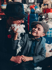 New Year's festive mood. A happy father with his son have fun and make an artificial New Year's beard.