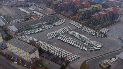 Fototapeta premium Lockdown due corona virus results also in stopped public transport - showing full bus garage packed with public transport buses.