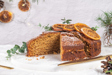 Christmas orange and spice cake. Decorated with dried oranges on kitchen countertop