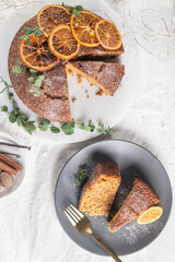 Christmas orange and spice cake. Decorated with dried oranges on kitchen countertop