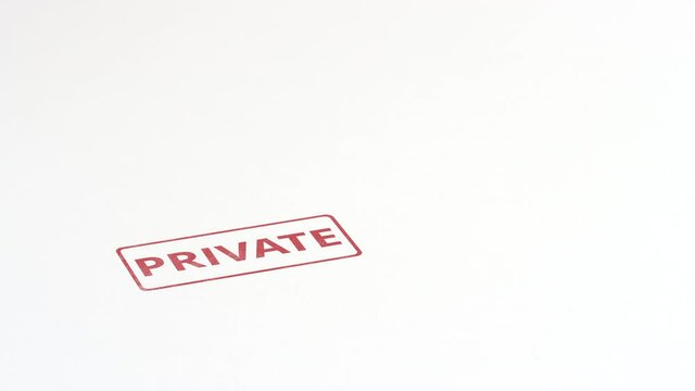 Putting red PRIVATE rubber stamp on the paper, close-up shot