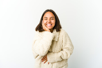 Young mixed race woman laughs happily and has fun keeping hands on stomach.