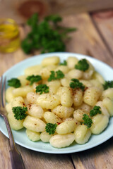 Selective focus. Macro. Gnocchi with olive oil and spices on a plate. A serving of gnocchi.
