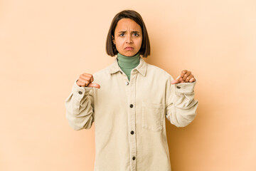 Young hispanic woman isolated showing a dislike gesture, thumbs down. Disagreement concept.