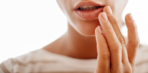 Young woman suffering from herpes on lips. Treatment of herpes infection and virus
