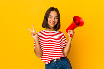 Young hispanic woman holding a megaphone showing number two with fingers.