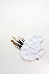 palette for paints and brushes on a white background