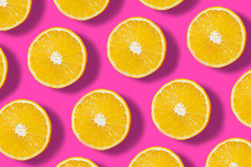 Obraz premium Top down view on pink abstract background with slices of ripe orange or lemon citrus in pattern - trendy minimal flat lay food summer concept