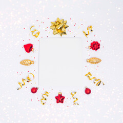 Christmas postcard with paper blank, red and golden decorations, ribbon, confetti and sparkles on light background. Flay lay, top view, copy space