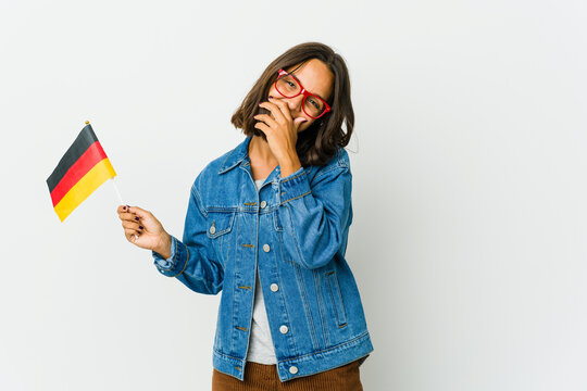 Young latin woman holding a german flag isolated on white background