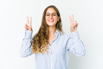 Young caucasian woman showing victory sign and smiling broadly.