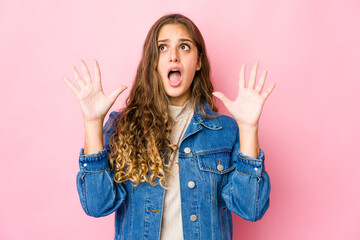 Young caucasian woman screaming to the sky, looking up, frustrated.