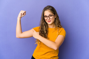 Young caucasian cute woman showing strength gesture with arms, symbol of power