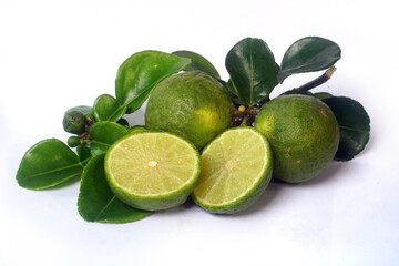 Kaffir Lime or Citrus hystrix. Some are whole, some have been sliced. Focus selected, white background